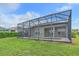 View of the backyard with the screened-in pool and green lawn at 6266 Buckingham St, Sarasota, FL 34238