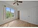 Bright bedroom featuring wood floors, a ceiling fan, and a large window with outdoor views at 6266 Buckingham St, Sarasota, FL 34238