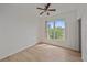 Sunlit bedroom with laminate flooring and a large window overlooking the front yard at 6266 Buckingham St, Sarasota, FL 34238