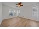 Bright bedroom features wood floors, ceiling fan, and natural light from multiple windows at 6266 Buckingham St, Sarasota, FL 34238