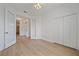 Spacious bedroom with light wood floors, closet, ceiling fan, and glass french doors at 6266 Buckingham St, Sarasota, FL 34238