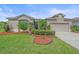 Attractive single-story home with lush front yard featuring a green lawn, mulch accents and mature shrubs at 6266 Buckingham St, Sarasota, FL 34238