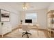 Well-lit home office with wood floors, ceiling fan, desk, closet and built-in shelving at 6266 Buckingham St, Sarasota, FL 34238