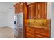 Kitchen featuring stainless steel fridge, wood cabinets, and granite countertops at 6266 Buckingham St, Sarasota, FL 34238