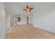 Open concept living room with wood floors and ceiling fan leads to kitchen and entrance at 6266 Buckingham St, Sarasota, FL 34238