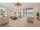 Bright living room with neutral tones, a ceiling fan, and a view of the pool and lake at 6266 Buckingham St, Sarasota, FL 34238