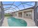 View of the pool from the screened lanai, showing the steps and the home at 6266 Buckingham St, Sarasota, FL 34238
