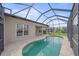 Home exterior featuring a kidney-shaped screened pool in the backyard at 6266 Buckingham St, Sarasota, FL 34238