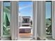 Balcony view through white curtains, showcasing outdoor seating and a glimpse of a neighboring home at 6317 Turtle Grass Dr, Bradenton, FL 34210