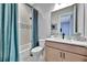 Well-lit bathroom showcases a shower with a blue curtain, and a vanity with a white countertop at 6317 Turtle Grass Dr, Bradenton, FL 34210