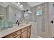 A stylish bathroom with a wooden vanity and a tiled shower that features a window at 6317 Turtle Grass Dr, Bradenton, FL 34210