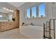 Sunlit bathroom with a soaking tub, sleek fixtures, and a double vanity, creating a serene retreat at 6317 Turtle Grass Dr, Bradenton, FL 34210