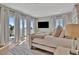 Bright bedroom featuring a stylish white bed frame, a mounted TV, and balcony access at 6317 Turtle Grass Dr, Bradenton, FL 34210