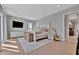 Bright bedroom featuring a stylish white bed frame, a mounted TV, and wood flooring at 6317 Turtle Grass Dr, Bradenton, FL 34210