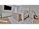 Bright bedroom featuring a stylish white bed frame, a mounted TV, and wood flooring at 6317 Turtle Grass Dr, Bradenton, FL 34210