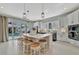 Modern kitchen with a large island, stool seating, white cabinets, and access to the backyard pool area at 6317 Turtle Grass Dr, Bradenton, FL 34210