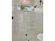Shower featuring modern shower head, white tiles and a window showcasing the palm trees at 6317 Turtle Grass Dr, Bradenton, FL 34210