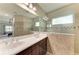 Bathroom with double sink vanity, large mirror, and tiled shower-tub combination at 6516 Palm Leaf Ct, Sarasota, FL 34243