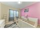Bright bedroom featuring twin beds, window, light pink accent wall, and closet at 6516 Palm Leaf Ct, Sarasota, FL 34243