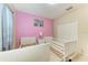 Cozy bedroom features twin beds, light pink accent wall, and large closet at 6516 Palm Leaf Ct, Sarasota, FL 34243