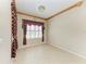 A well-lit empty room with tile flooring and a window with patterned burgundy valance at 6516 Palm Leaf Ct, Sarasota, FL 34243