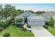 Charming single-story home featuring a well-manicured lawn, landscaped garden beds, and a two-car garage at 6516 Palm Leaf Ct, Sarasota, FL 34243