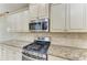 Close-up of the kitchen area with stainless steel stove, microwave and granite countertops at 6516 Palm Leaf Ct, Sarasota, FL 34243
