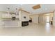 Open concept living space with tile floors, a kitchen bar, and views of the front entrance at 6516 Palm Leaf Ct, Sarasota, FL 34243
