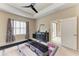Comfortable main bedroom featuring large window, tray ceiling with fan, and ensuite access at 6516 Palm Leaf Ct, Sarasota, FL 34243