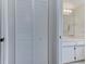 Compact bathroom featuring a storage closet, vanity, mirror, and bright lighting fixtures at 7110 Fairway Bend Ln # 181, Sarasota, FL 34243