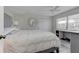 Calm and serene bedroom with a plush white bed, built-in desk, ceiling fan, and ample natural light at 7110 Fairway Bend Ln # 181, Sarasota, FL 34243