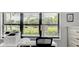 Bright home office setup with a desk, printer, and large window offering picturesque green space views at 7110 Fairway Bend Ln # 181, Sarasota, FL 34243