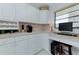 Well-lit kitchen with white cabinets, laminate countertops, and a built-in desk area with natural light at 7110 Fairway Bend Ln # 181, Sarasota, FL 34243