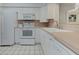 Well-lit kitchen featuring tile flooring, and white appliances and cabinetry at 7110 Fairway Bend Ln # 181, Sarasota, FL 34243