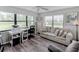 Bright living space featuring a neutral sofa, modern furnishings, and view overlooking exterior green space at 7110 Fairway Bend Ln # 181, Sarasota, FL 34243