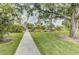 Pathway leading to the community pool area with lush landscaping and mature trees at 7110 Fairway Bend Ln # 181, Sarasota, FL 34243