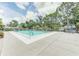 Community pool surrounded by lush greenery and lounge chairs under a bright sky at 7110 Fairway Bend Ln # 181, Sarasota, FL 34243