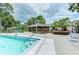 Inviting community pool with lounge chairs and a building surrounded by mature trees at 7110 Fairway Bend Ln # 181, Sarasota, FL 34243