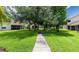 Well-manicured backyard with mature trees and a sidewalk to explore at 7137 Cedar Hollow Cir, Bradenton, FL 34203