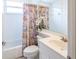 Cozy bathroom with a floral shower curtain, white vanity, and tiled walls at 7137 Cedar Hollow Cir, Bradenton, FL 34203