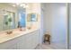 Bright bathroom with double sinks, white cabinets and tile floors at 7137 Cedar Hollow Cir, Bradenton, FL 34203
