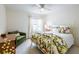 Bright bedroom features a metal bed frame with floral bedding and an accent green sofa at 7137 Cedar Hollow Cir, Bradenton, FL 34203