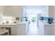 Well-lit kitchen boasts white cabinets, stainless steel appliances, blue backsplash, and convenient desk space at 7137 Cedar Hollow Cir, Bradenton, FL 34203