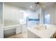 Bright kitchen featuring white cabinets, tiled backsplash, and an eat-in island at 7137 Cedar Hollow Cir, Bradenton, FL 34203