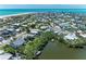 An aerial view showcases a neighborhood, highlighting the home's proximity to the river and the ocean at 733 Holly Rd, Anna Maria, FL 34216