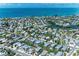 An aerial view showcases a neighborhood, highlighting the home's proximity to the river and the ocean at 733 Holly Rd, Anna Maria, FL 34216