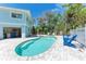 Private backyard featuring a sparkling pool, spa, lounge chairs, and lush landscaping at 733 Holly Rd, Anna Maria, FL 34216