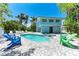 Inviting backyard featuring a sparkling pool, spa, lounge chairs, and lush landscaping at 733 Holly Rd, Anna Maria, FL 34216