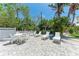 Tranquil backyard with white lounge chairs and lush landscaping, ideal for relaxation at 733 Holly Rd, Anna Maria, FL 34216