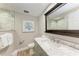Bathroom features marble countertops, framed mirror, tile shower and decorative artwork at 733 Holly Rd, Anna Maria, FL 34216
